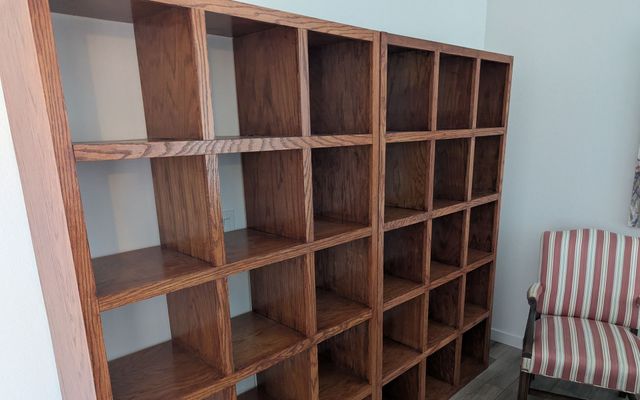 Empty custom oak bookshelf unit with a grid of square cubbies before being filled with books