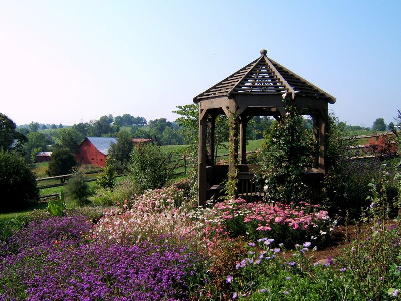 Finished backyard octagonal gazebo with nearby barn visible in the background