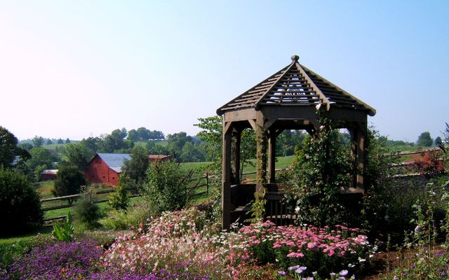 Finished backyard octagonal gazebo with nearby barn visible in the background