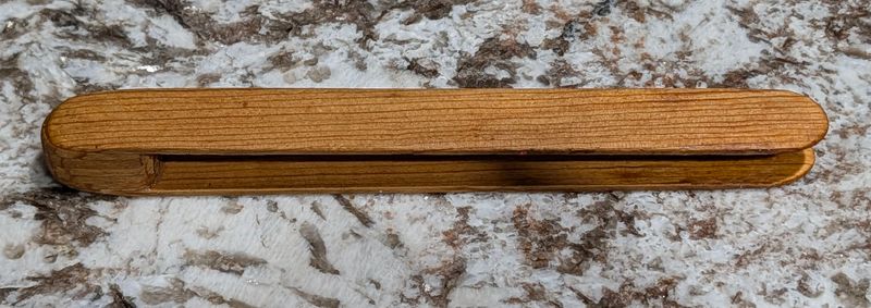 Handmade wooden toaster tongs shaped to fit toaster slots and grip toast safely