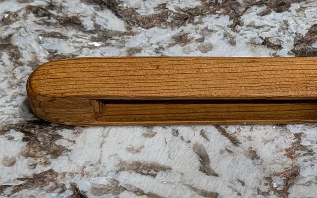 Handmade wooden toaster tongs shaped to fit toaster slots and grip toast safely